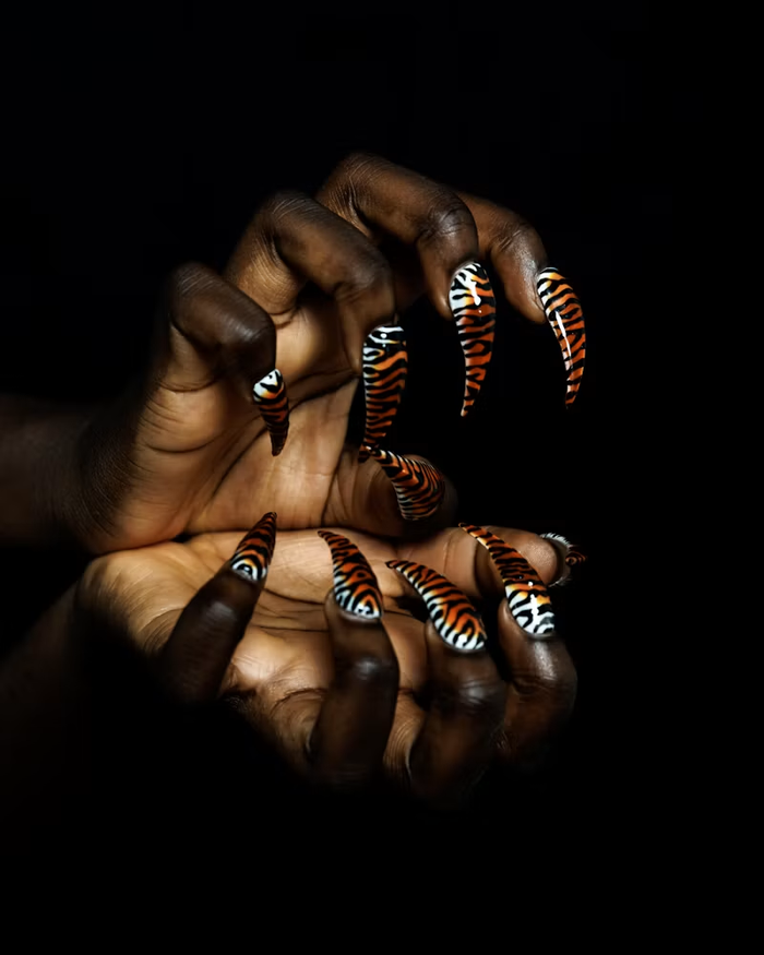 Tiger-striped nail art against a black background