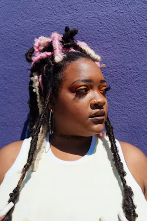 Locs with pink accents and hoop earrings