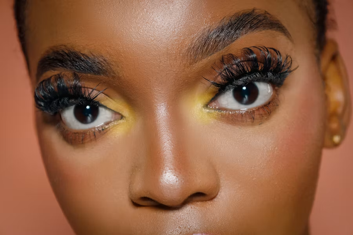 Close-up of dramatic curled eyelashes and gold eye makeup