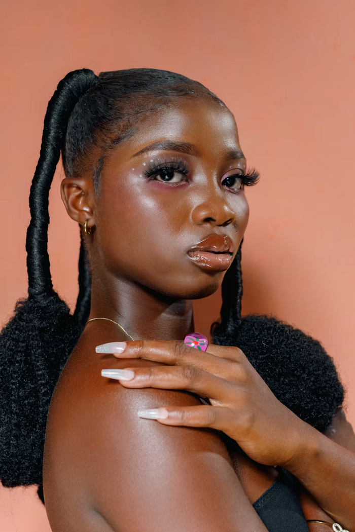 Beauty portrait with dramatic lashes, gold hoops, and statement nails
