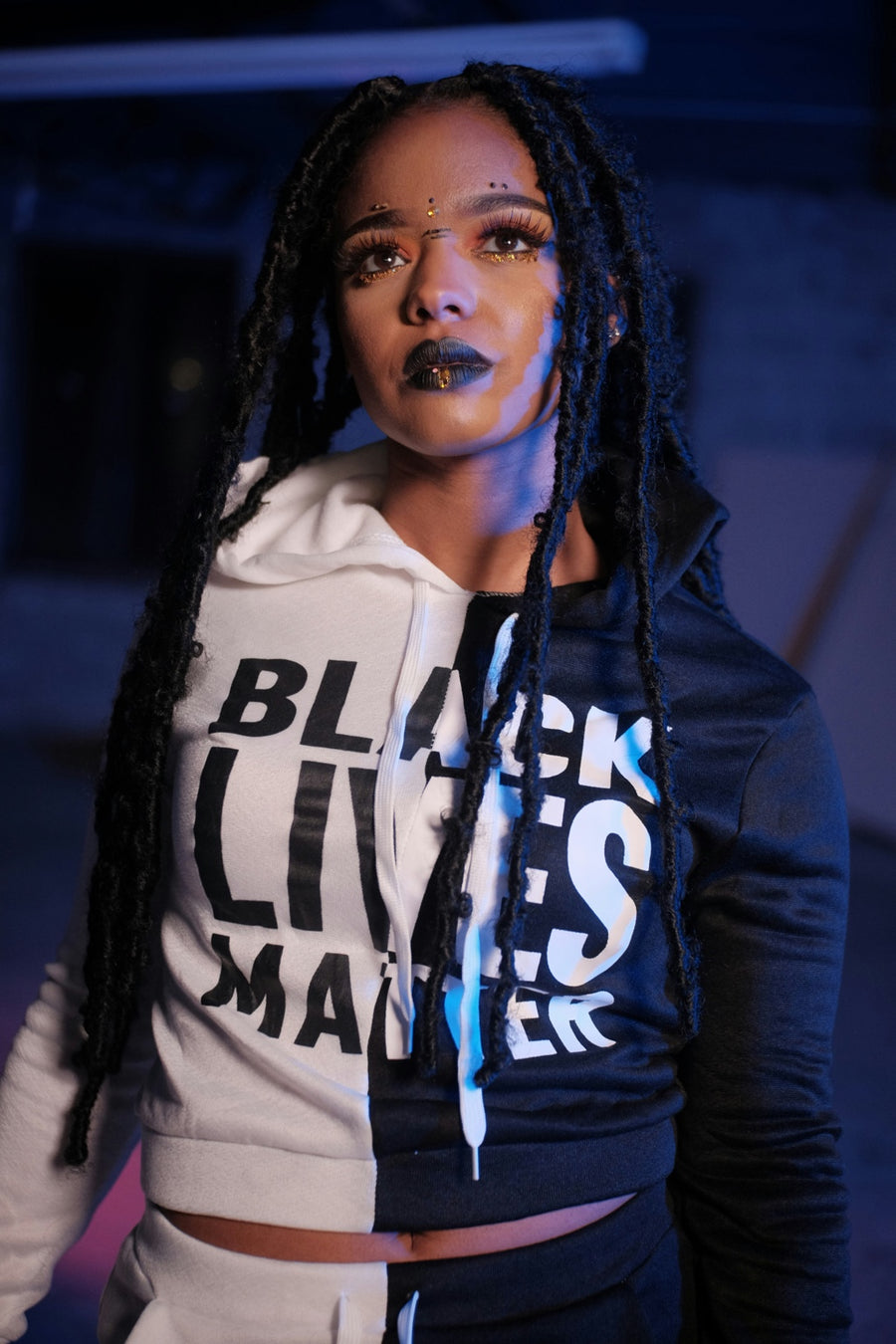 Long locs and Black Lives Matter hoodie in blue lighting
